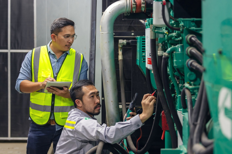 Technician performing preventive maintenance on a diesel generator